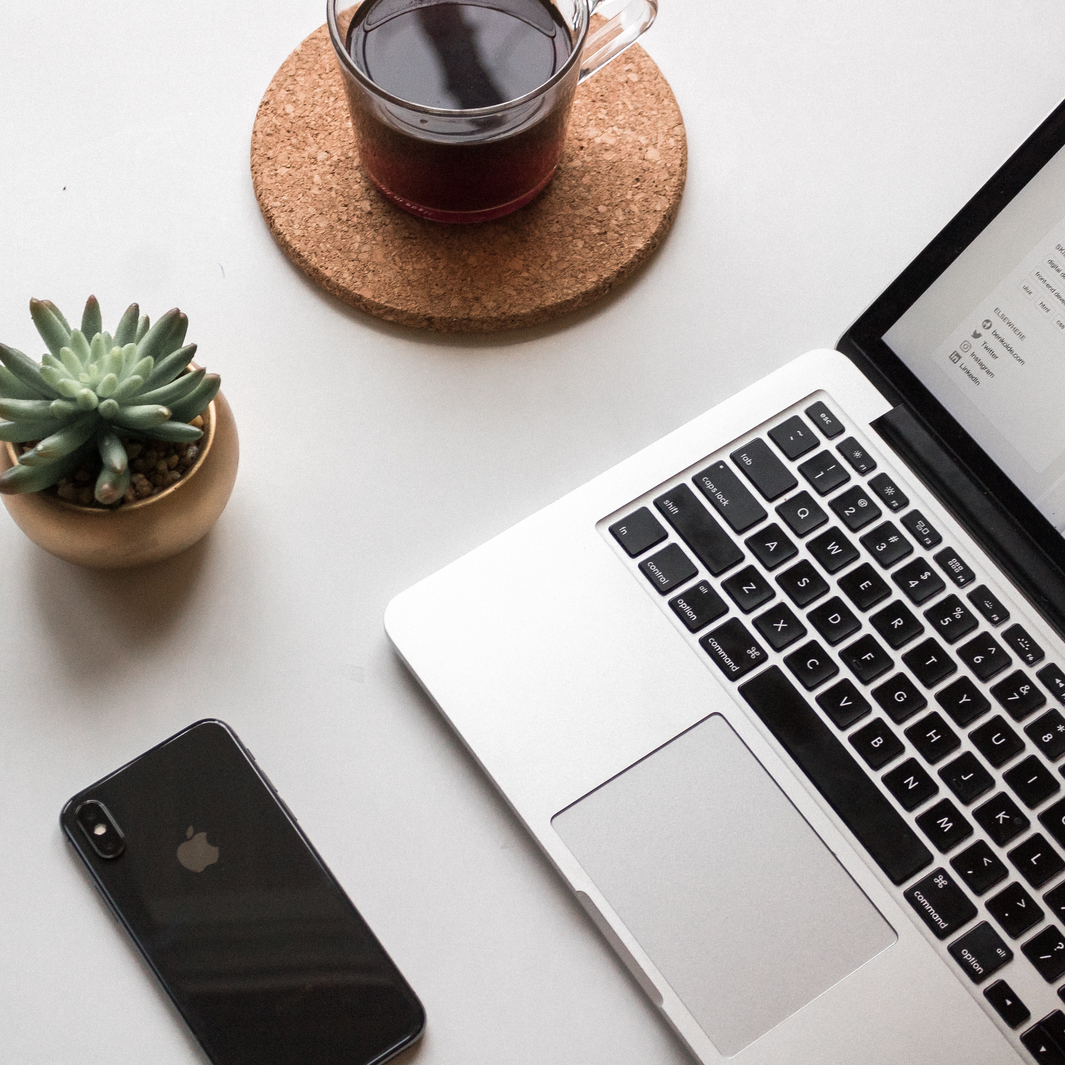 a laptop beside mobile phone and a cup of tea